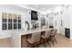 Bright open kitchen featuring a kitchen island with barstools, stainless steel appliances and white cabinetry at 6996 E Mighty Saguaro Way, Scottsdale, AZ 85266