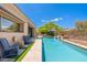 Backyard pool with water feature, lounge chairs, and a covered patio area at 6996 E Mighty Saguaro Way, Scottsdale, AZ 85266