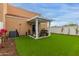 Backyard featuring a covered patio, artificial turf, and landscaping for outdoor enjoyment at 7064 W Lincoln St, Peoria, AZ 85345
