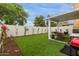 Serene backyard space with artificial turf, covered patio, and blooming bougainvillea plants at 7064 W Lincoln St, Peoria, AZ 85345