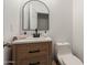 Stylish half bathroom featuring a wood vanity, modern sink, and a round mirror at 7064 W Lincoln St, Peoria, AZ 85345