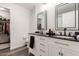 Modern bathroom featuring double sinks, black countertops, framed mirrors, and a separate closet at 7064 W Lincoln St, Peoria, AZ 85345