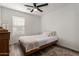 Cozy bedroom features a twin bed, neutral decor, wood-look floors, and a window at 7064 W Lincoln St, Peoria, AZ 85345