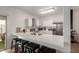 Bright kitchen features white cabinets, stainless appliances, and a spacious quartz countertop breakfast bar at 7064 W Lincoln St, Peoria, AZ 85345