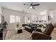 Modern living room with wood floors, leather sofa, ceiling fan, and kitchen view at 7064 W Lincoln St, Peoria, AZ 85345
