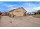 Single-story home featuring a tan exterior, a two-car garage, and a spacious driveway at 7114 W Oregon Ave, Glendale, AZ 85303