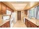 Efficient kitchen features wood cabinets, white appliances, and tile flooring at 7114 W Oregon Ave, Glendale, AZ 85303