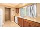 This kitchen offers wood cabinets, a stainless steel sink and a window with curtains at 7114 W Oregon Ave, Glendale, AZ 85303