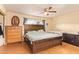 This main bedroom features a ceiling fan, wood floors and a wooden bedframe at 7114 W Oregon Ave, Glendale, AZ 85303