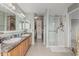 Bright bathroom featuring double vanity, walk-in shower, and accessible walk-in closet at 7308 S 29Th Ln, Phoenix, AZ 85041