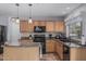 Kitchen with wood cabinets, black appliances, granite countertops, tile backsplash, and island at 7308 S 29Th Ln, Phoenix, AZ 85041