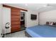 Bedroom featuring a sliding barn door leading to the bathroom, ceiling fan and TV at 8314 E Vista Dr, Scottsdale, AZ 85250