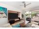 Bright living room with hardwood floors, modern TV, and a sliding glass door to the pool at 8314 E Vista Dr, Scottsdale, AZ 85250