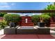 Outdoor fire pit with stone surround, lush landscaping and dark red fencing at 8314 E Vista Dr, Scottsdale, AZ 85250