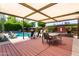 Stylish patio with a pergola, dining area, lounge chairs, and lush landscaping surrounding the pool at 8314 E Vista Dr, Scottsdale, AZ 85250