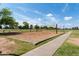 Sand volleyball court with net set up in a spacious park area, framed by trees and blue sky at 8314 E Vista Dr, Scottsdale, AZ 85250