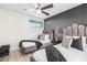 Chic bedroom with gray accent wall, two twin beds, and a modern ceiling fan at 8437 E Bonnie Rose Ave, Scottsdale, AZ 85250