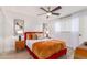 Bright bedroom with a red bed frame, wooden floors, and a modern ceiling fan at 8437 E Bonnie Rose Ave, Scottsdale, AZ 85250