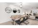 Dining room with a wood table, seating for six, modern light fixture, and three decorative round mirrors at 8437 E Bonnie Rose Ave, Scottsdale, AZ 85250