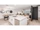 Bright, open kitchen with stainless steel appliances, white cabinets, large island, and views into the living room at 8437 E Bonnie Rose Ave, Scottsdale, AZ 85250