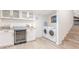 Bright laundry room features a wine fridge, granite countertops, and steps to another level at 8437 E Bonnie Rose Ave, Scottsdale, AZ 85250