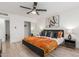 Bright bedroom with orange quilt, black and white pillows, wood-look floors, and closet with sliding doors at 8437 E Bonnie Rose Ave, Scottsdale, AZ 85250