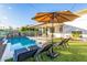 Backyard pool with ample seating, mature trees, and a decorative mural at 8437 E Bonnie Rose Ave, Scottsdale, AZ 85250