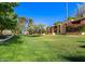 Community buildings featuring lush landscaping, mature trees, and inviting walkways at 8500 E Indian School Rd # 233, Scottsdale, AZ 85251