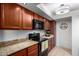 Kitchen with wooden cabinets, stainless steel appliances, granite countertops and recessed lighting at 8500 E Indian School Rd # 233, Scottsdale, AZ 85251