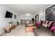 Open-concept living room with sectional, ottoman, television, and dining area with views to hallway and bathroom at 8500 E Indian School Rd # 233, Scottsdale, AZ 85251