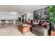 Open-concept living room with dining area, comfortable sectional sofa, ottoman, and large mural of a city at 8500 E Indian School Rd # 233, Scottsdale, AZ 85251