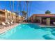 Community pool with clear blue water, surrounded by lounge chairs and palm trees under a bright blue sky at 8500 E Indian School Rd # 233, Scottsdale, AZ 85251