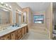 Bathroom with double sinks, wood cabinets, and a tub, offering a comfortable space at 8600 E Broadway Rd # 30, Mesa, AZ 85208