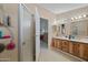 Bathroom featuring double sinks, wood cabinetry, and a shower with sleek glass doors at 8600 E Broadway Rd # 30, Mesa, AZ 85208
