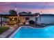 Relaxing backyard with a sparkling pool, covered patio, outdoor seating, and lush greenery for entertaining at 8728 E Monte Vista Rd, Scottsdale, AZ 85257