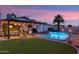 Inviting backyard featuring a pristine pool, lush turf, and a cozy patio with string lights, perfect for outdoor relaxation at 8728 E Monte Vista Rd, Scottsdale, AZ 85257
