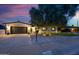 Charming home featuring a well-manicured front yard, dark garage door, updated lighting, and healthy trees at 8728 E Monte Vista Rd, Scottsdale, AZ 85257