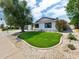 Well-maintained front yard with lush green turf, decorative rock landscaping, and mature shade trees at 8728 E Monte Vista Rd, Scottsdale, AZ 85257