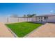 A simple backyard with a grass area and a high concrete wall at 8802 W Monterey Way, Phoenix, AZ 85037