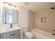 Bright bathroom featuring a modern vanity, mirror, and shower-tub combo at 8802 W Monterey Way, Phoenix, AZ 85037