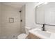 Modern bathroom featuring a tiled walk-in shower and a vanity with a framed mirror at 8802 W Monterey Way, Phoenix, AZ 85037