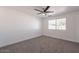 A bright bedroom with a ceiling fan, window, and neutral carpet at 8802 W Monterey Way, Phoenix, AZ 85037