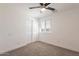 A clean bedroom with a ceiling fan, closet and a window at 8802 W Monterey Way, Phoenix, AZ 85037