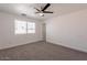 Well-lit bedroom with a ceiling fan, window, and neutral carpet at 8802 W Monterey Way, Phoenix, AZ 85037