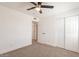 The bedroom has a ceiling fan, closet and neutral carpet at 8802 W Monterey Way, Phoenix, AZ 85037