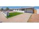Inviting single-story home with a well-kept lawn, driveway, and white picket fence at 8802 W Monterey Way, Phoenix, AZ 85037