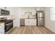 Bright kitchen with stainless steel appliances, wooden countertops, and wood flooring at 8802 W Monterey Way, Phoenix, AZ 85037