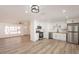 Bright, open kitchen with stainless steel appliances and white cabinets, seamlessly flowing to living area at 8802 W Monterey Way, Phoenix, AZ 85037