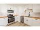 Modern kitchen featuring stainless steel appliances, white cabinets, and wood countertops at 8802 W Monterey Way, Phoenix, AZ 85037