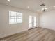 Bright living room with wood flooring, a large window, and access to the backyard through glass doors at 8802 W Monterey Way, Phoenix, AZ 85037